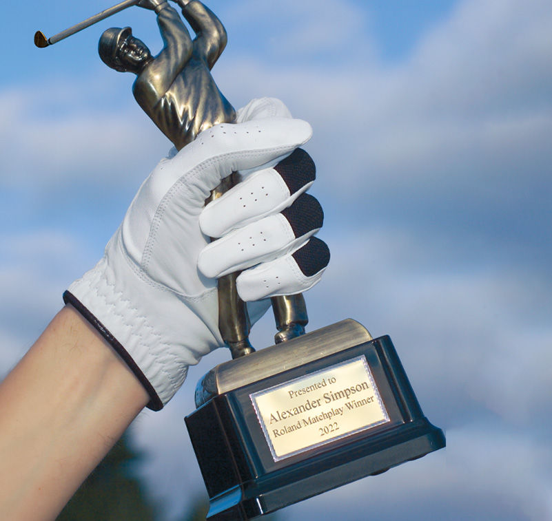 Osoba trzyma trofeum golfowe
