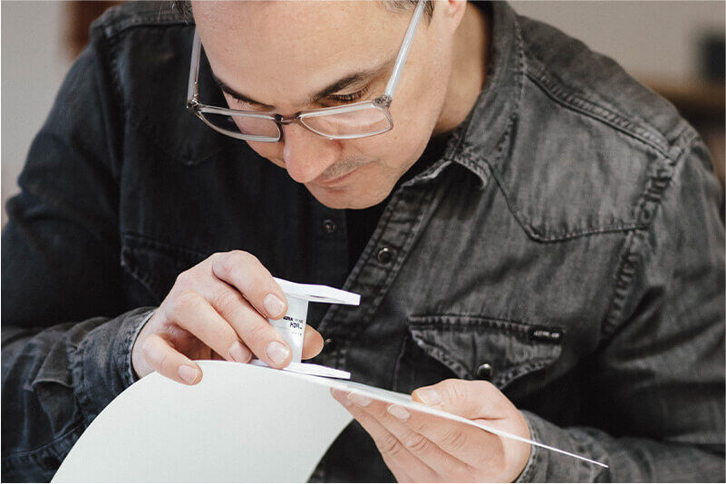Süßmann Ron de mockupz.de inspectant un prototype d’impression sur packaging