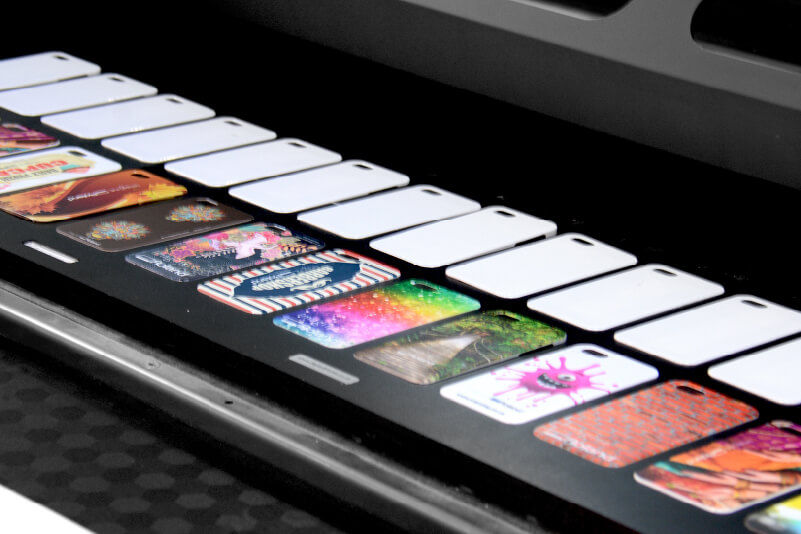 Several phone cases in a UV printing jig