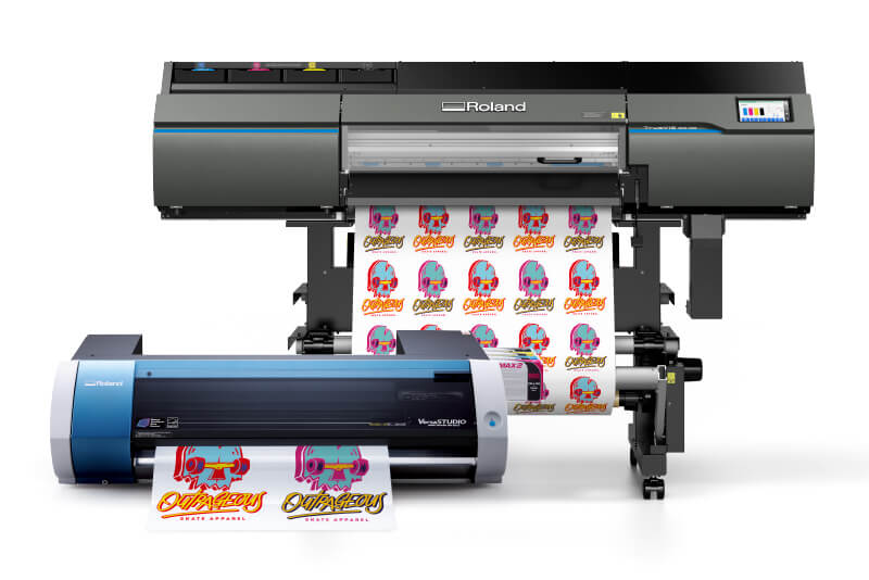 Une petite machine d'impression de stickers devant une imprimante plus grande