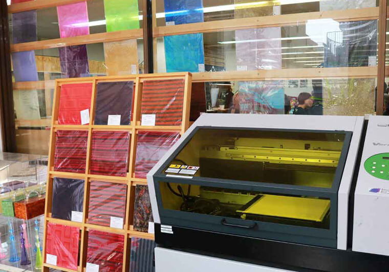 A Roland VersaUV LEF-12 UV printer is set up in the Miyuki Acryl studio