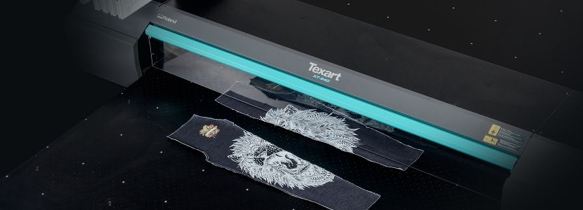 Denim being printed on a flatbed direct-to-textile printer