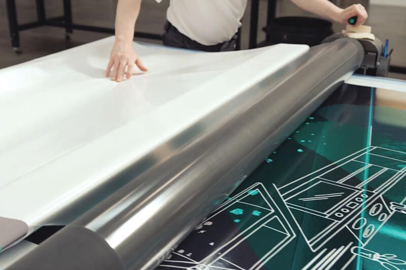 Applying laminate to printed roll-to-roll output.