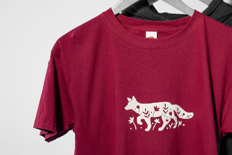A red shirt with a white fox HTV transfer on it