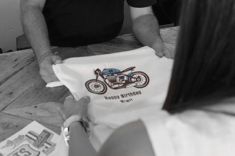 A person holding a shirt with a motorcycle on it