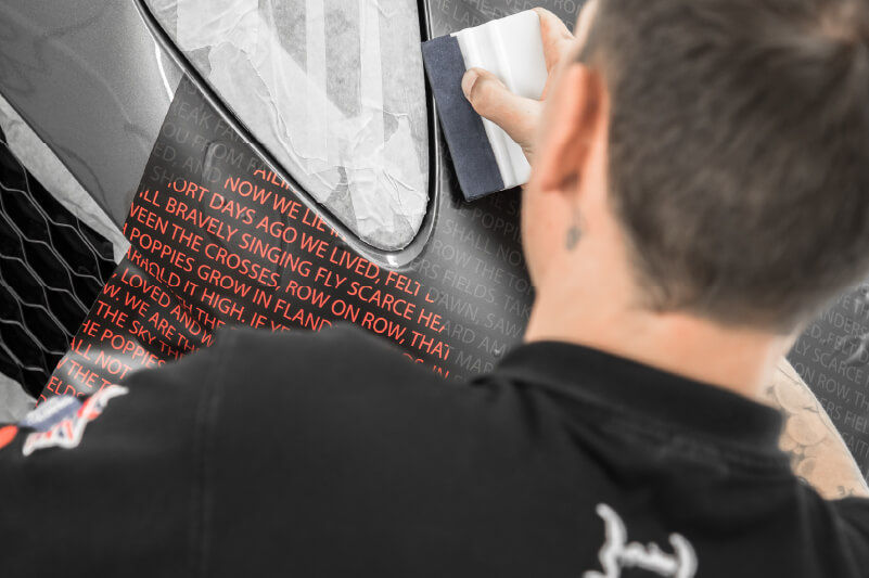 Applying a vinyl wrap around a headlight (Source: Mission Motorsport)