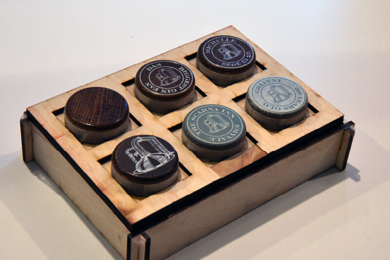 Six customised bottle corks in a printing jig