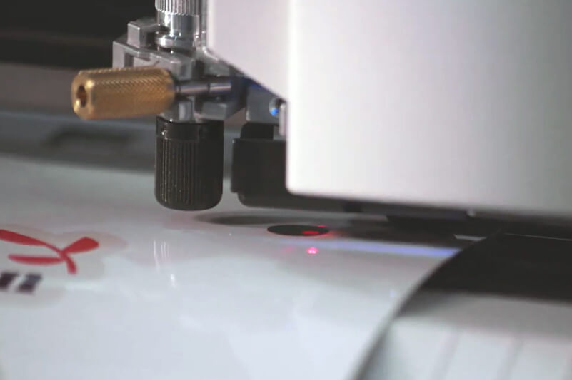 A vinyl cutter reading printed registration marks