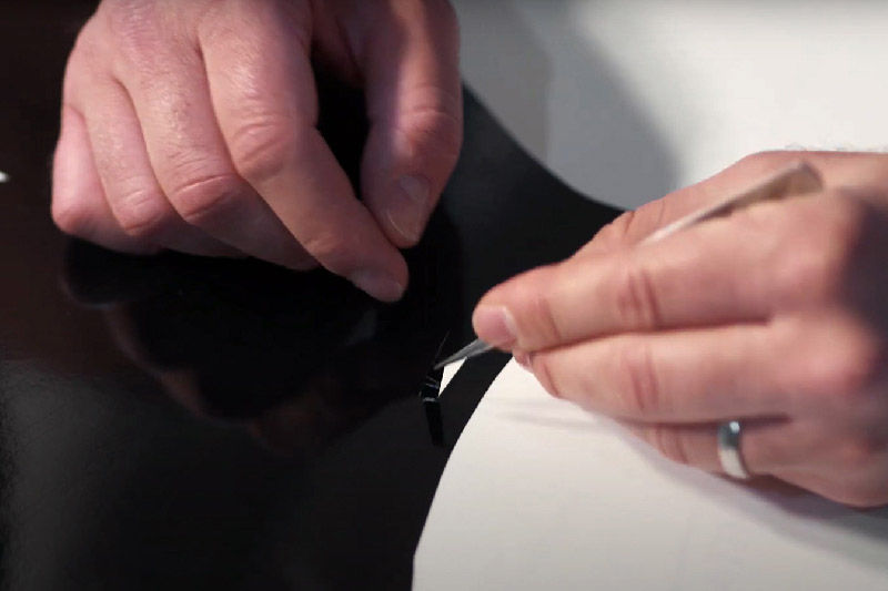 A person weeding the black vinyl flower stem