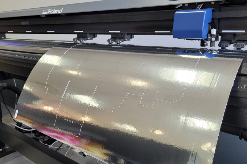 Metallic card being cut with a large-format cutter
