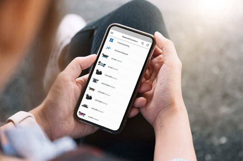 Una persona sujeta un teléfono con la aplicación Roland DG Connect