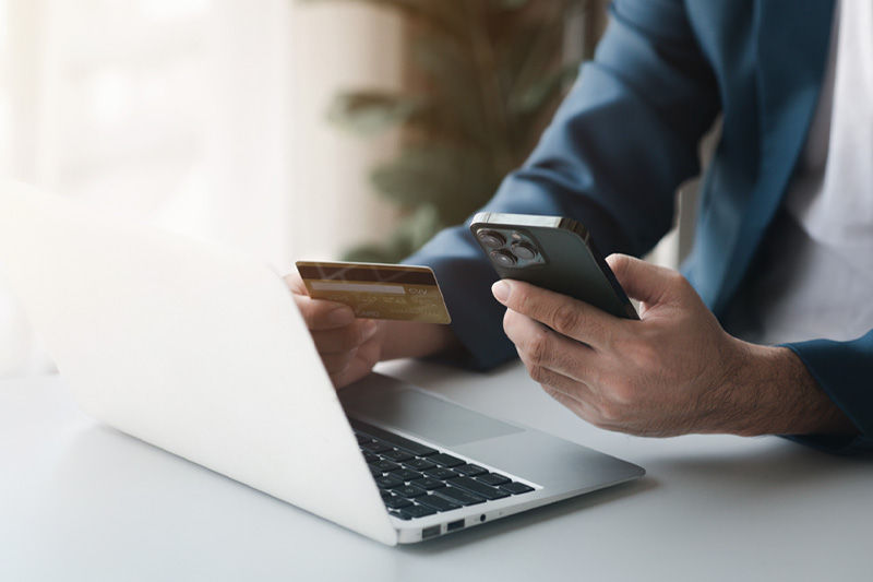 A person holding a credit card and a phone
