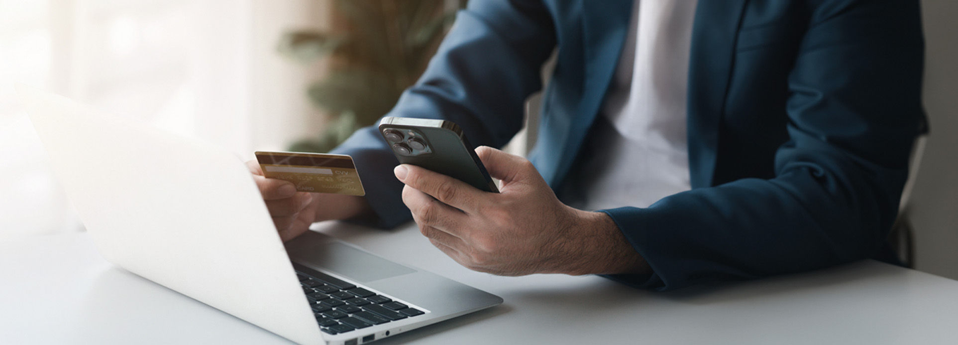 A person holding a credit card and a phone