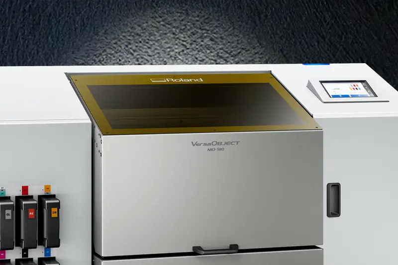 Impressora plana UV Roland MO-180 sobre um fundo escuro