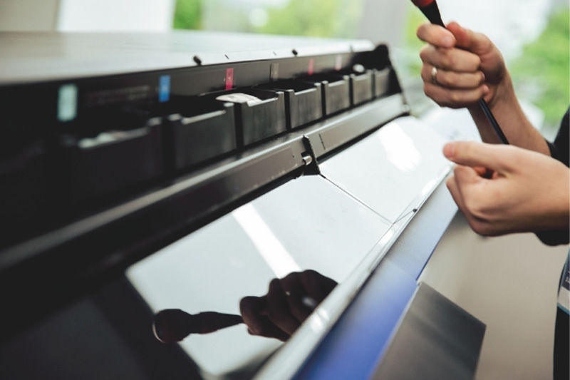 A Roland-certified engineer working on a printer