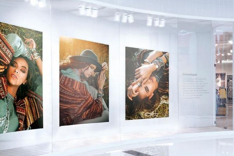Outside a retail shop store front showing three vibrant UV printed images of models