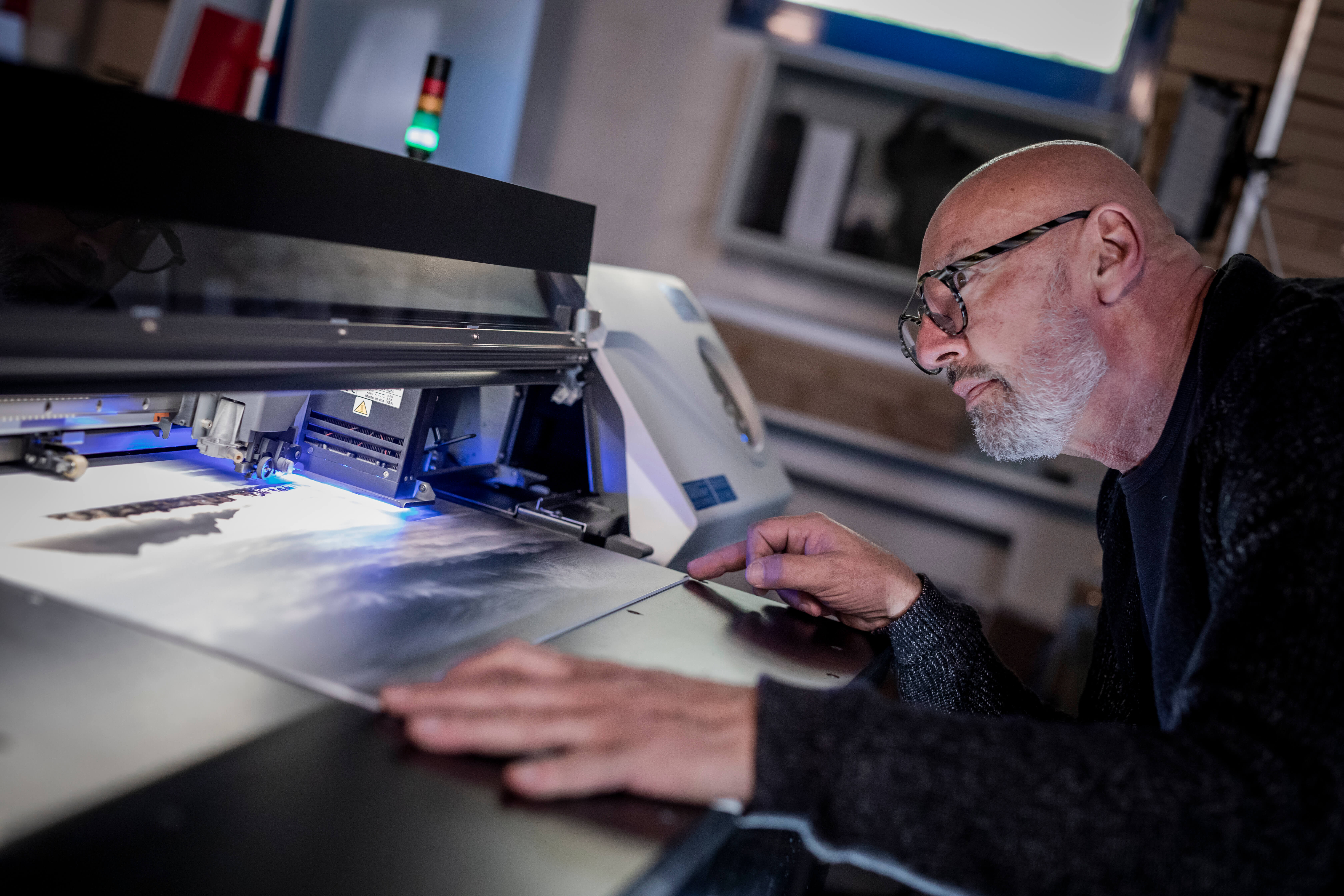 <figure>Le photographe vérifie le rendu des couleurs de l’impression, réalisée avec la VersaUV LEC-2.
